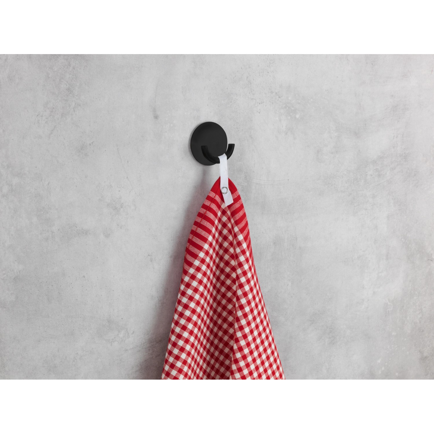 Schwarzer Wenko Küchenhaken Rondo aus Edelstahl mit rot-weiß kariertem Geschirrtuch.