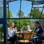 Juliana Gewächshaus Orangerie 15 in Schwarz-Anthrazit mit Familie beim Essen im Garten.