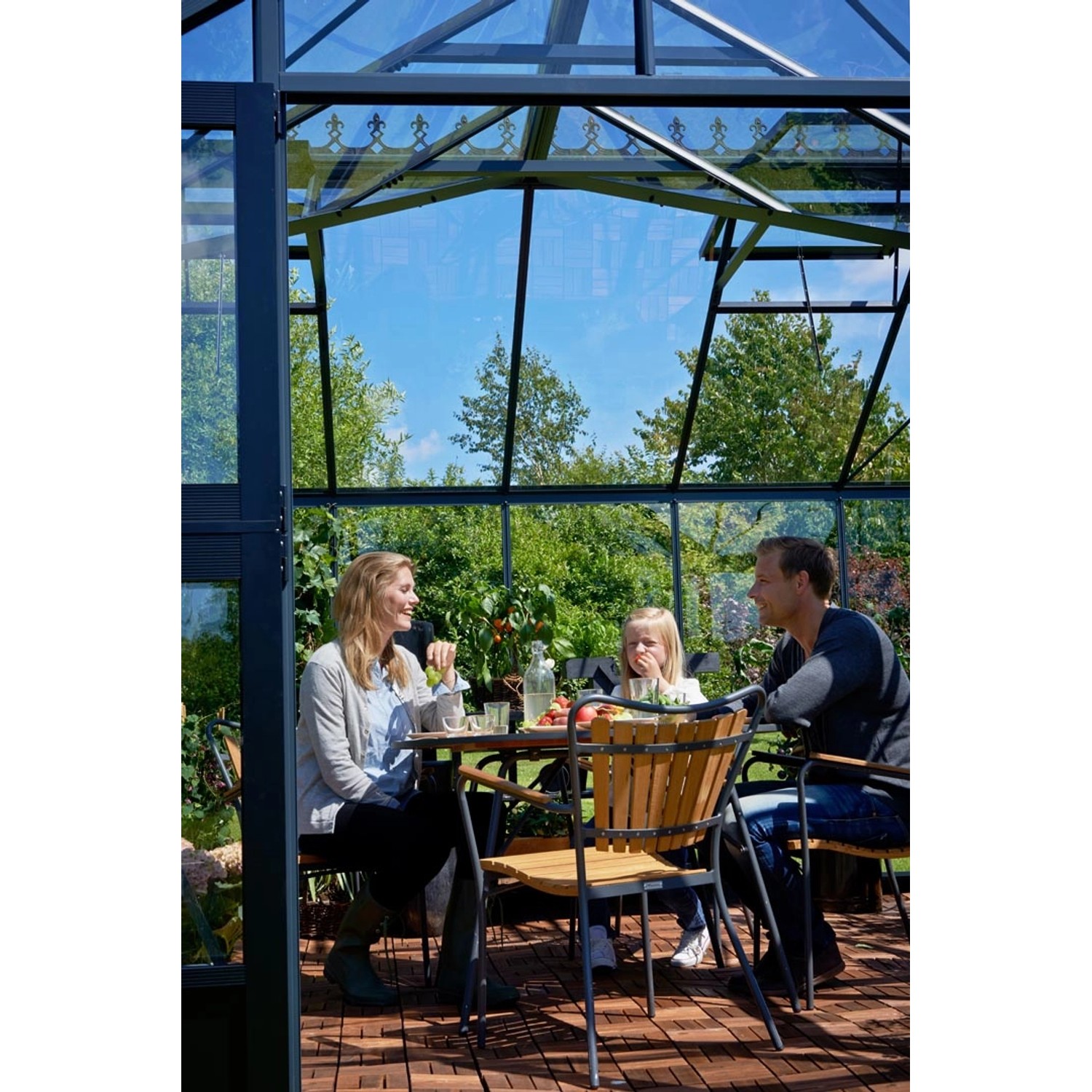 Juliana Gewächshaus Orangerie 15 in Schwarz-Anthrazit mit Familie beim Essen im Garten.