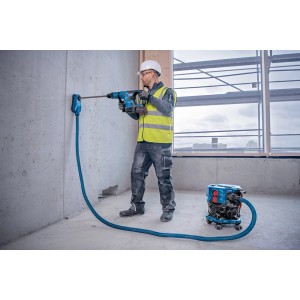 Bosch Professional GAS 18V-12 MC Akku-Sauger im Einsatz mit Bohrhammer an Wand. Nass- & Trockensauger.