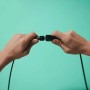 Detailaufnahme: Zwei Hände verbinden die Stecker der WiZ Outdoor LED-Außenstandleuchte.