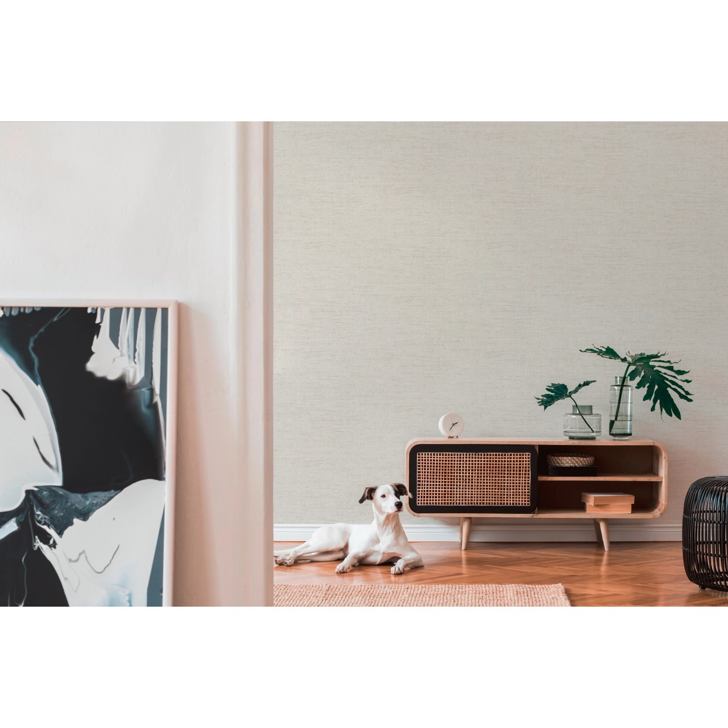 Helle, leicht strukturierte Vliestapete in Weiß-Beige an einer Wohnzimmerwand.