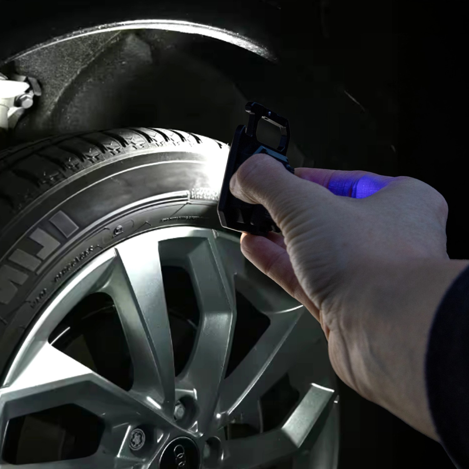LED Akku-Taschenlampe als Schlüsselanhänger leuchtet einen Reifen aus. Kompaktes, dimmbares Design.