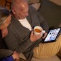 Paar entspannt mit Tablet und Tasse Tee im warmen Licht. E14 LED Lampe sorgt für gemütliche Atmosphäre.