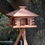 Rustikales XL-Vogelfutterhaus im Blockhaus-Stil mit Holzdach auf optionalem Ständer.