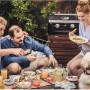 Gruppe genießt Grillabend mit Campingaz Gas-Tischgrill Attitude 2100 LX im Garten.
