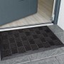 Schwarze Gummipinmatte 40x70 cm mit Beflockung vor einer Tür, ideal für den Außenbereich.