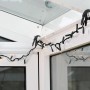Lichterkette befestigt mit wolfcraft Ergo-Federzwingen (3 cm) an einem Fensterrahmen.