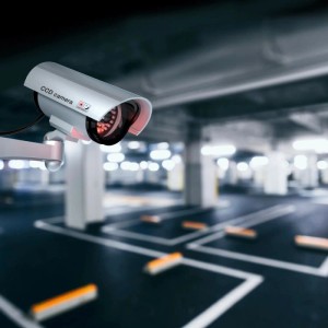 Silberne Kameraattrappe mit blinkendem LED-Licht zur Abschreckung, im Parkhaus.