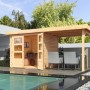 Karibu Express Gartenhaus Speedy A aus naturbelassenem Holz mit Anbaudach und Sitzbereich am Pool.