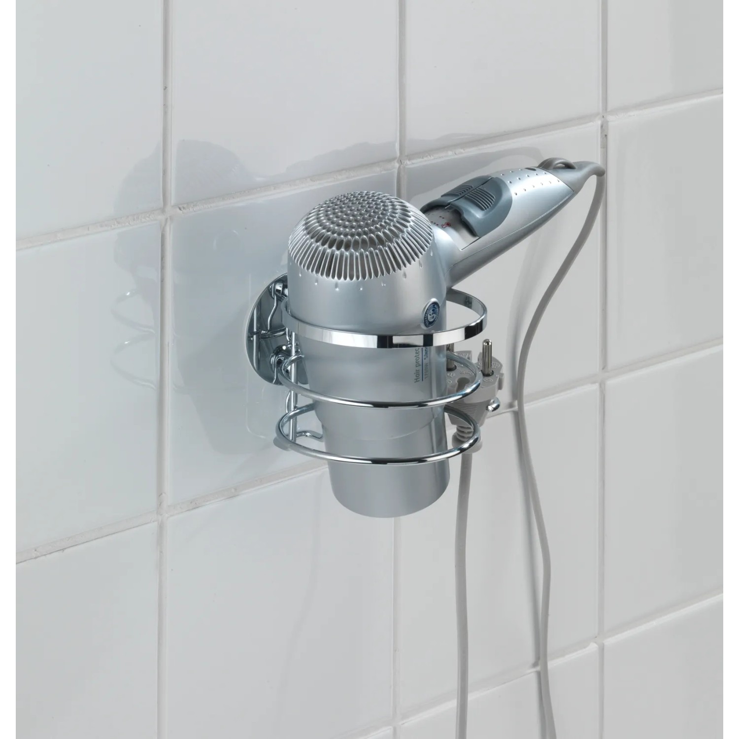 Wenko Turbo-Loc Haartrocknerhalter aus glänzendem Edelstahl mit Haartrockner an weißer Wand.