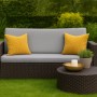 Graues 2-Sitzer Gartensofa mit gelben Kissen und passendem Tisch aus Polyrattan. Gemütliche Sitzecke.