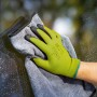 Hand mit LUX-TOOLS Arbeitshandschuh (Gr. 8) und Putzlappen beim Fensterputzen.