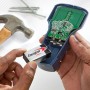 Energizer 9V Batterie wird in ein elektronisches Gerät eingesetzt. Werkzeug im Hintergrund.