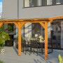 Skan Holz Terrassenüberdachung Bormio, Eiche Hell, mit Polycarbonat-Dach und Sitzgruppe.