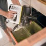 Kärcher Akku-Staubsauger VC 4 Cordless myHome beim Entleeren über einem Mülleimer.