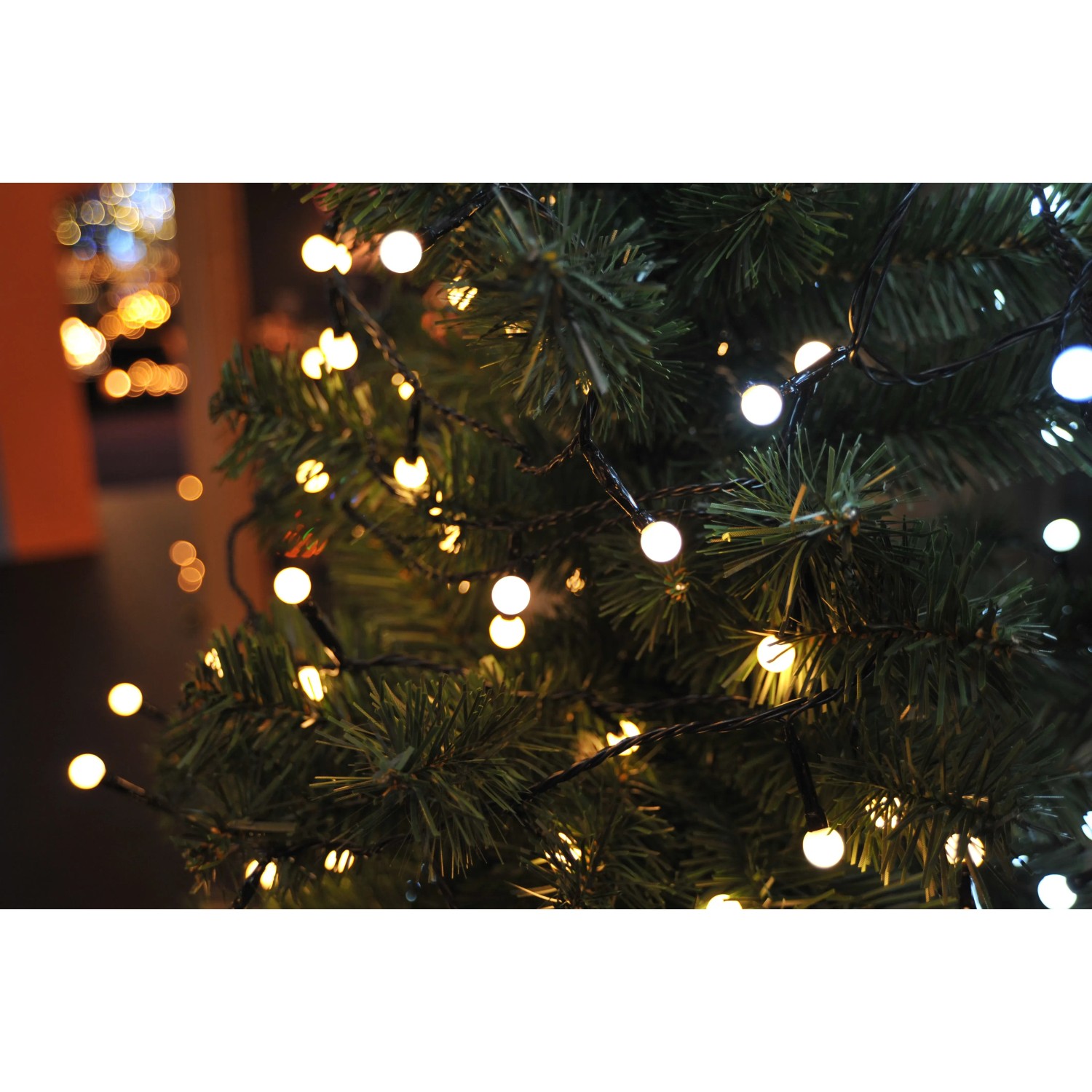 Konstsmide LED Lichterkette mit 80 warmweißen Globe-LEDs für Innen und Außen am Weihnachtsbaum.