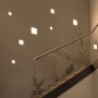 Eingebaute, eckige Paulmann LED-Einbaupanels Veluna VariFit (125x125 mm) an einer Wand neben einer Treppe.