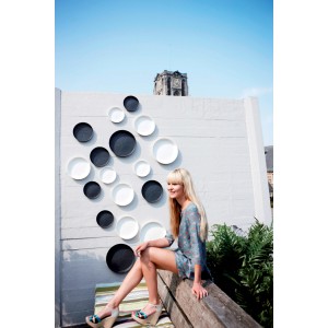 Elho Untersetzer Loft urban, Ø 28 cm, anthrazit, aus recyceltem Kunststoff, mit Frau auf Bank.