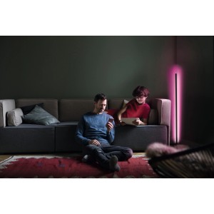 Schwarze Ledvance Smart+ WiFi Stehlampe Ecke, 142cm, mit indirekter, farbiger Beleuchtung im Wohnzimmer.