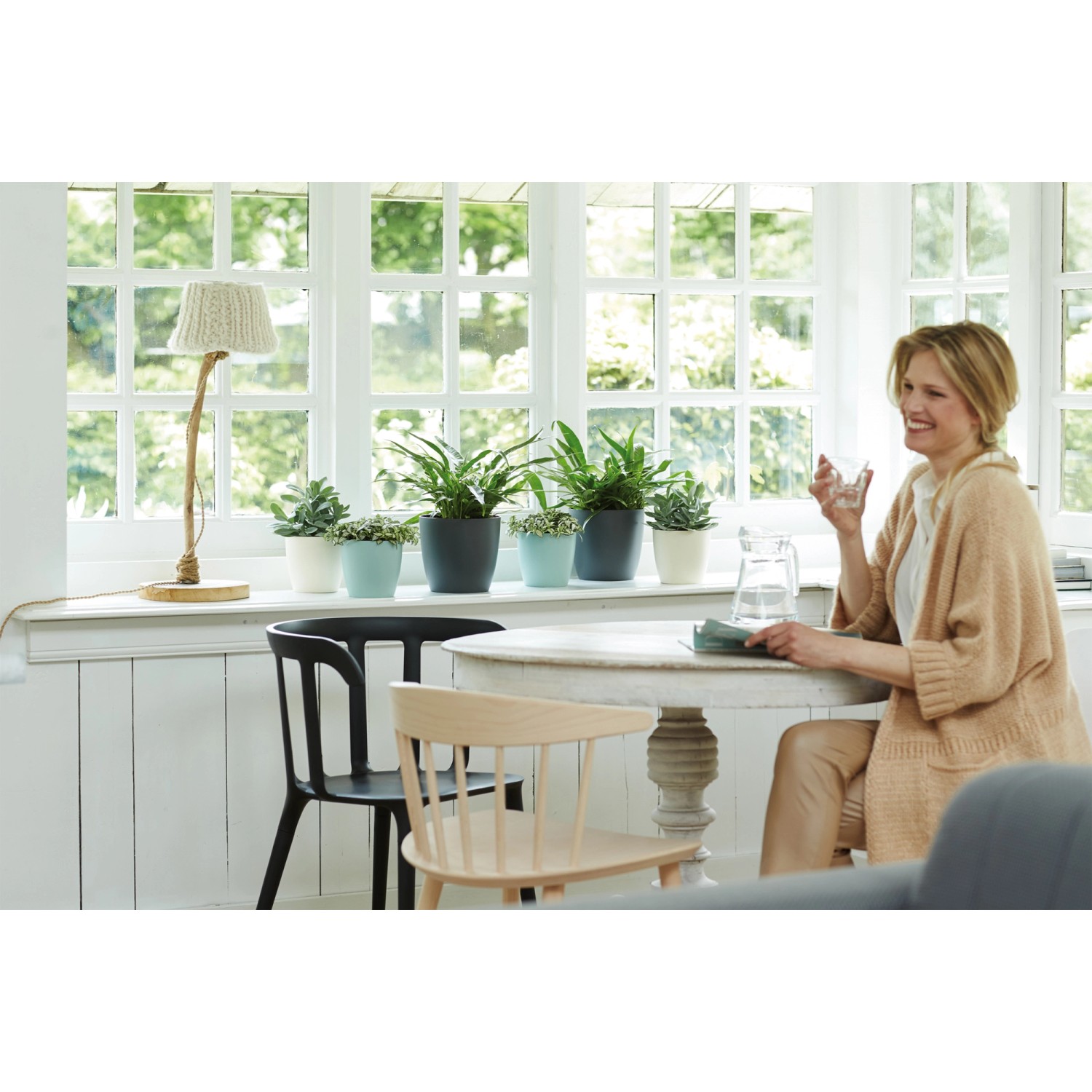 Elho Brussels runder Blumentopf Ø 14 in Mintgrün auf Fensterbank mit Pflanzen.