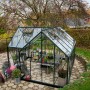 Halls Gewächshaus Garden Room, 12,9 m², grüne Aluminiumstruktur mit Sicherheitsglas, im Garten.