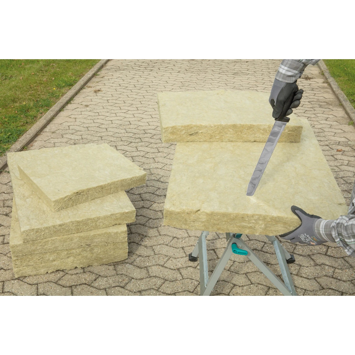 Wolfcraft Dämmstoffmesser schneidet Dämmstoffplatte auf Werkbank. Maurerwerkzeug mit 305 mm Klinge.