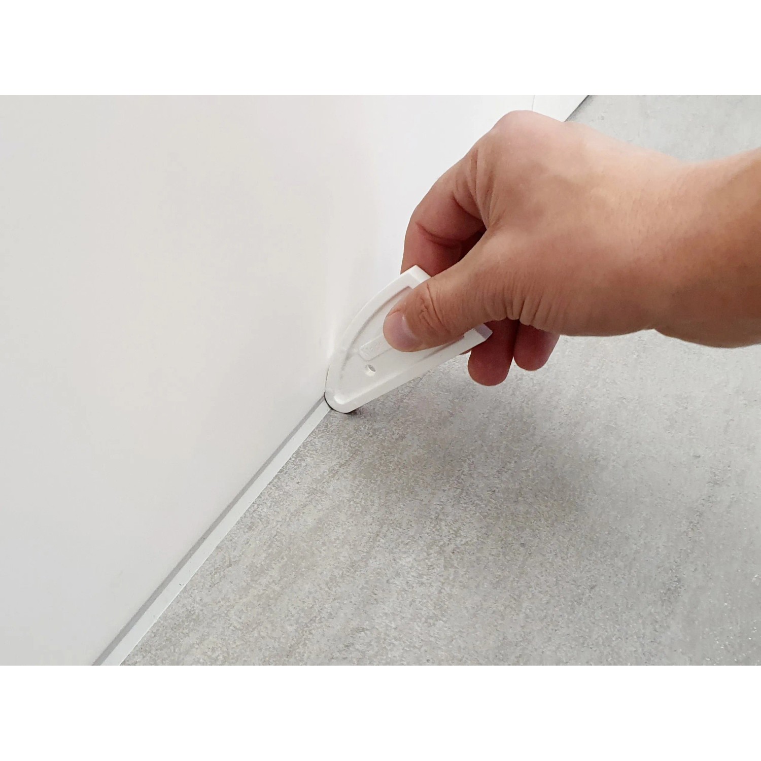 Hand nutzt Fugenglätter Universal an Fuge zwischen Wand und Boden.