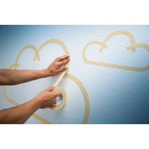 Anwendung von dehnbarem, beigem LUX Hochkrepp Klebeband zum Abkleben von Wolkenformen an einer Wand.