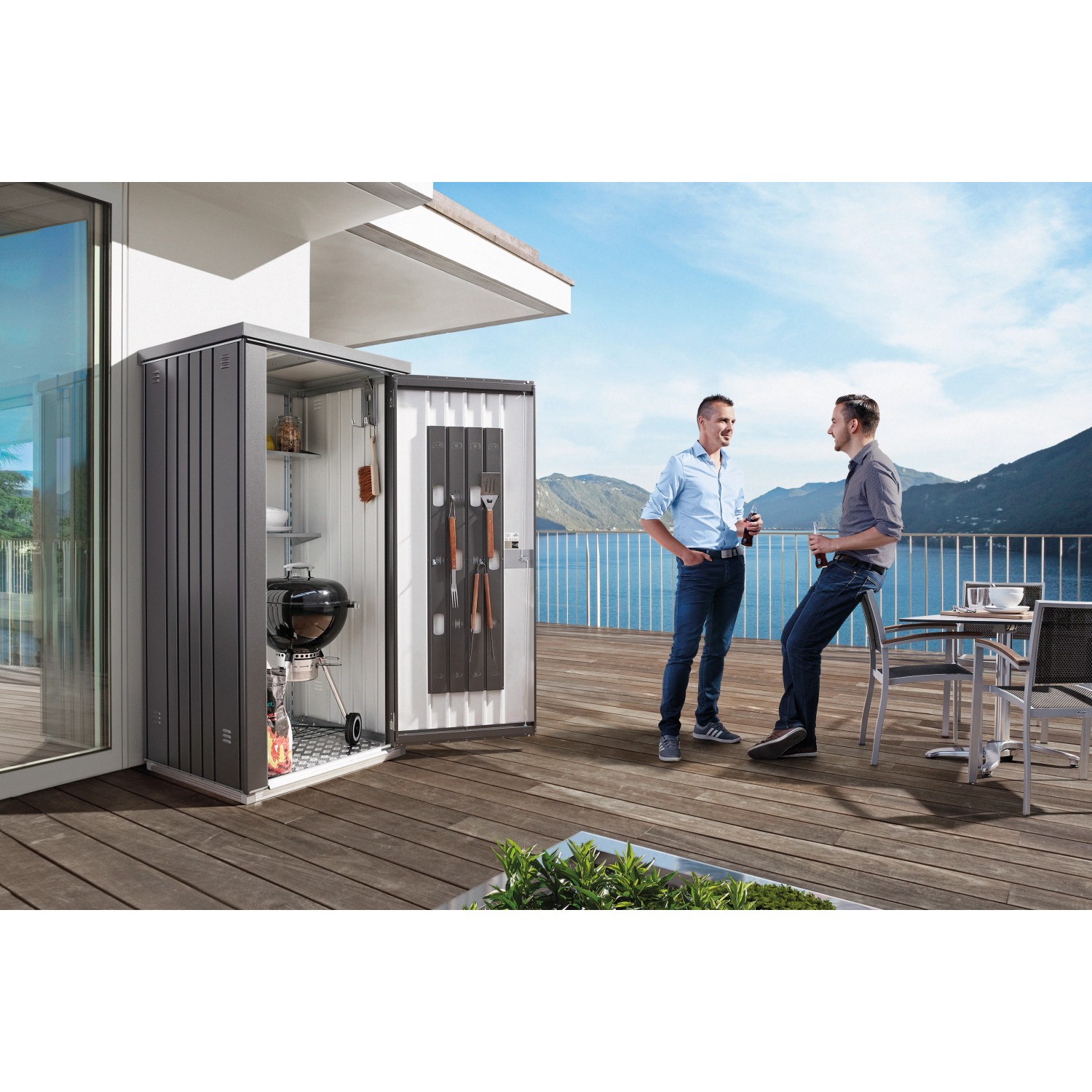 Biohort Geräteschrank Gr. 90 in Quarzgrau-Metallic mit Grill und Zubehör auf Terrasse.