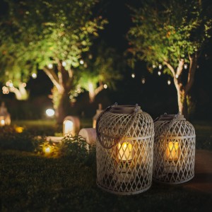Näve Dekoleuchte Korb Braun mit Solar-LED-Kerze (29 cm) im Garten bei Nacht.