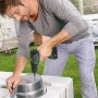 Mann bohrt mit dem Bosch 18V Akku-Bohrschrauber UniversalDrill 18V Solo ein Loch in einen Metalleimer.