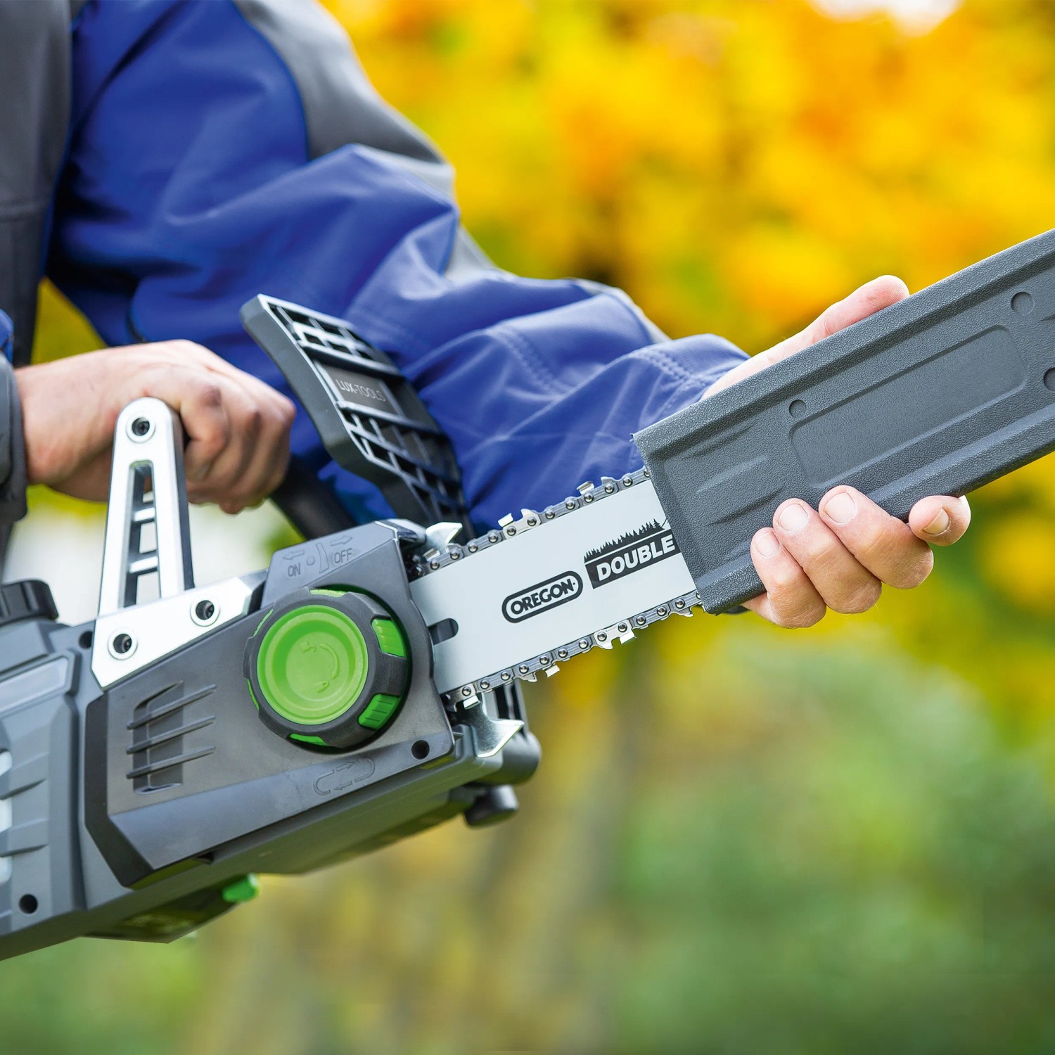 LUX Akku-Kettensäge A-KS-20/25 mit Schwertschutz, gehalten von einer Person. Ideal für Gartenarbeiten.