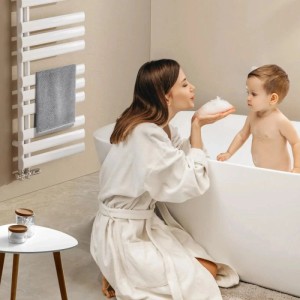 Weißer Emke Badheizkörper, ovaler Handtuchwärmer im Bad. Trocknet Handtücher, schafft warme Badezimmer-Atmosphäre.
