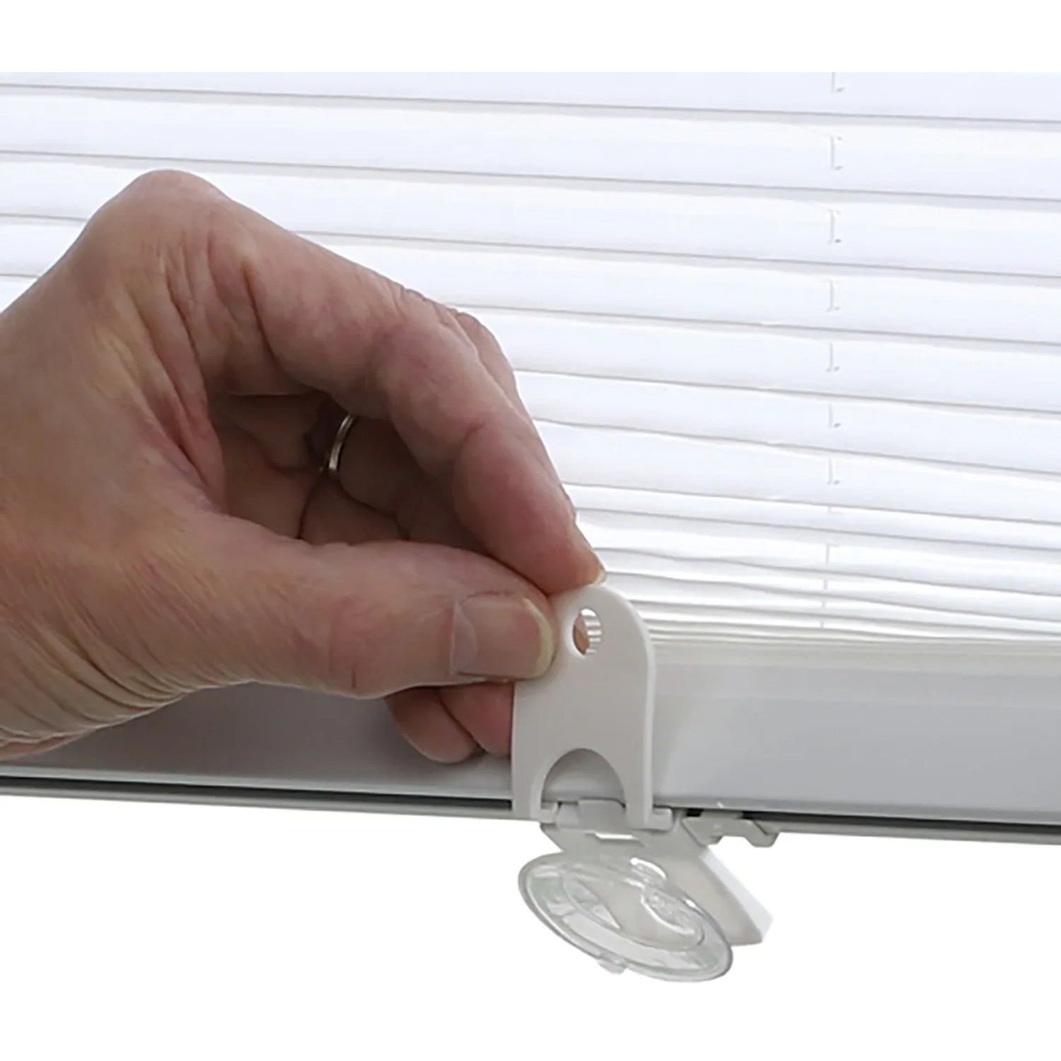 Montage des weißen Gardinia Dachfenster-Plissees mit Saugnäpfen am Fenster.