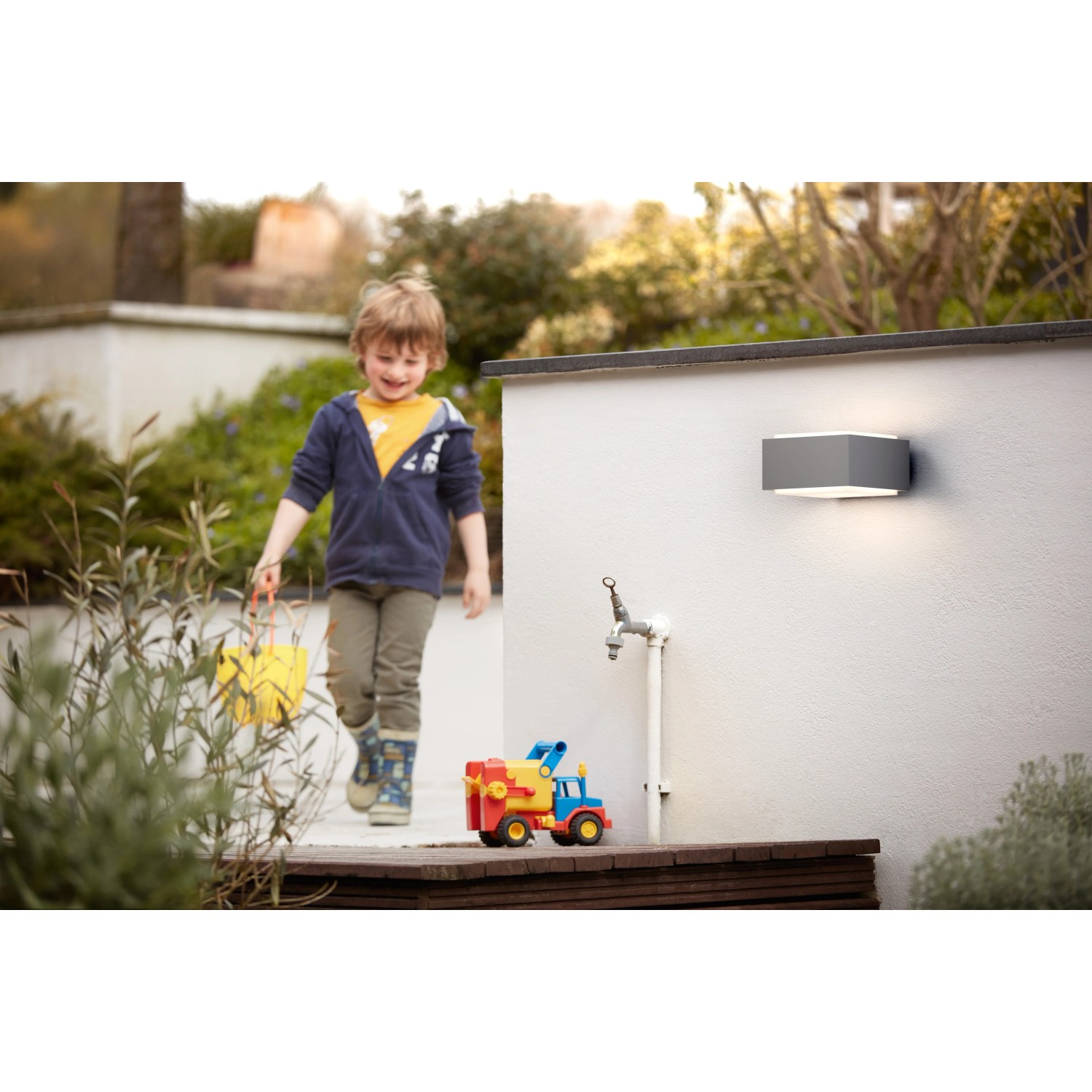 Moderne Philips myGarden Außenwandleuchte Hedgehog aus Edelstahl an einer weißen Hauswand.