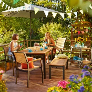 Gartenbank Bonlee 2-Sitzer aus FSC®-Holz mit Aluminiumgestell auf einer Terrasse mit Tisch und Stühlen.