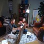 Szene mit Philips Hue Lampe: Paar montiert Bild im Wohnzimmer, beleuchtet von der smarten LED-Lampe.