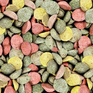 Kleine, bunte, runde Supravit Pferdeleckerlies mit Apfel und Kräutern in Grün, Gelb und Rot.