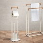 Freistehender Handtuchhalter aus Bambus und WC-Garnitur, weißes Gestell mit Holzakzenten.