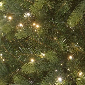 Nahaufnahme einer dichten Kunsttanne Ketola mit grünen Nadeln und leuchtenden kaltweißen sowie warmweißen LEDs.