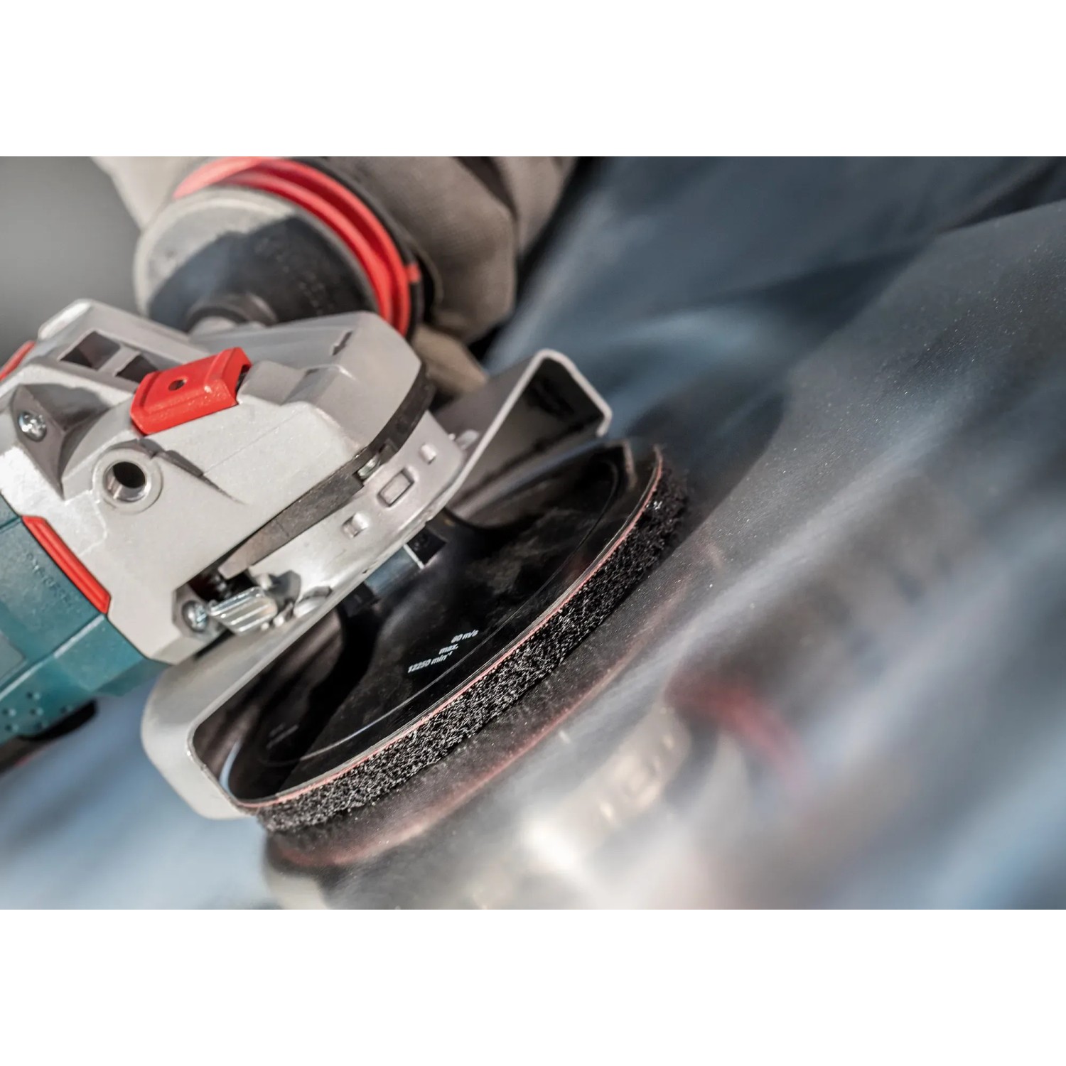 Bosch Expert Vliesscheibe N880 auf Exzenterschleifer beim Schleifen von Metall.