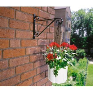 Schwarzer Wandhaken für Blumenampeln (30 cm) mit weißem Hängekorb und roten Blumen an einer Backsteinwand.