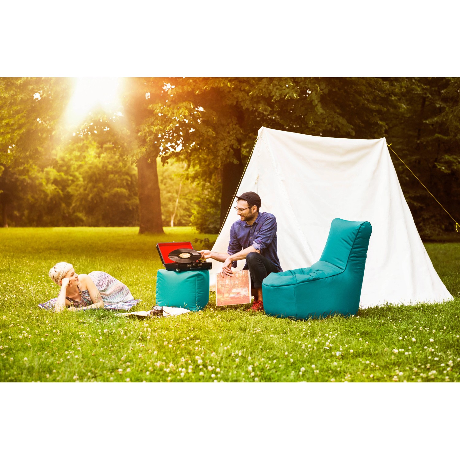 Sitting Point Sessel Swing Anthrazit im Garten mit Zelt, Plattenspieler und entspannten Personen.