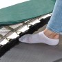 Detailaufnahme: Fuß auf dem Sprungtuch des grünen EXIT Allure Classic Trampolins.