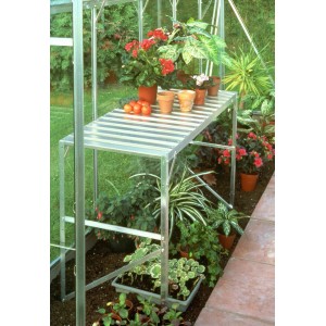 Alutisch mit einer Ablagefläche im Gewächshaus, bepflanzt mit Blumen und Gemüse.
