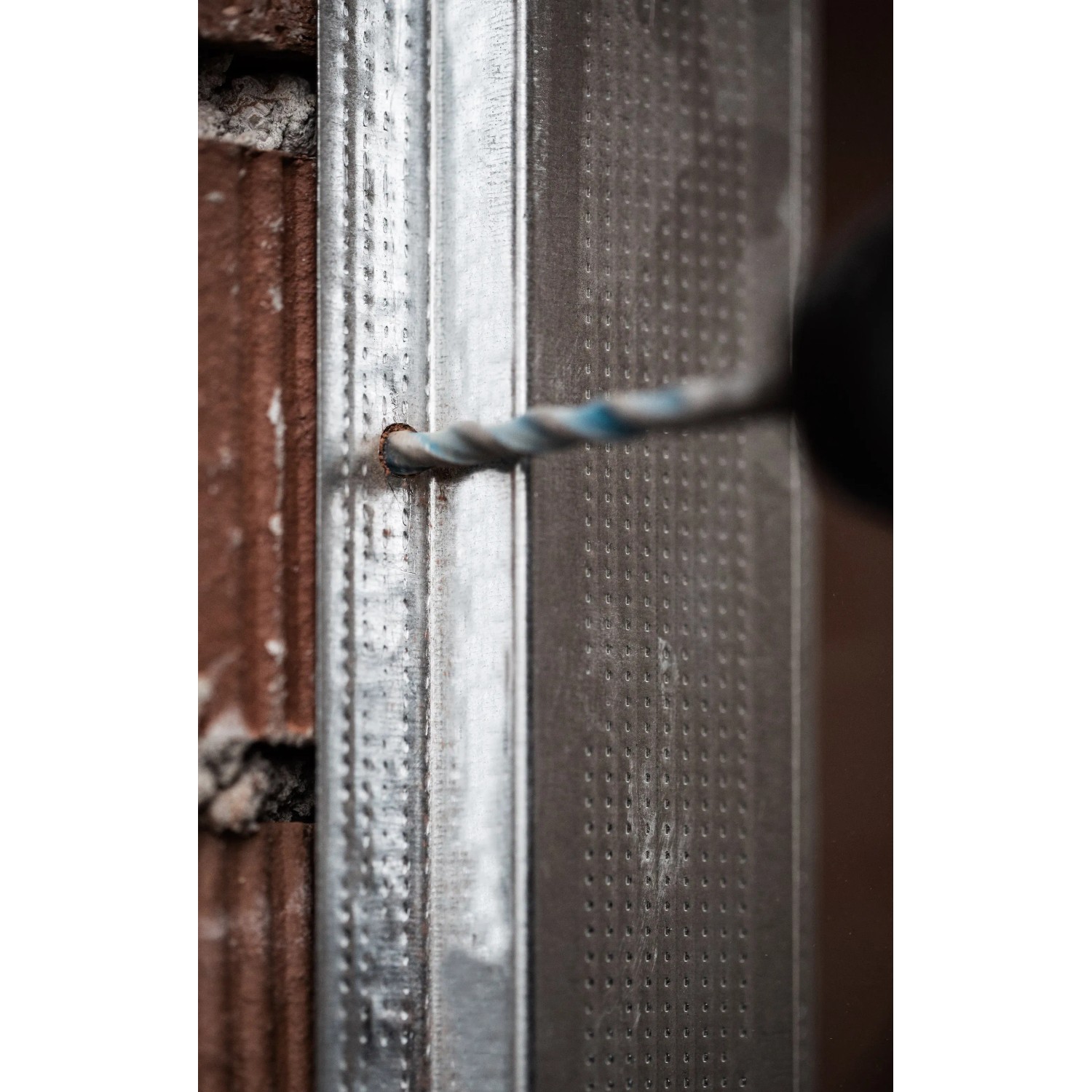 Bosch Expert Multi Construction Bohrer CYL-9 beim Bohren durch Metall in einer Wand.