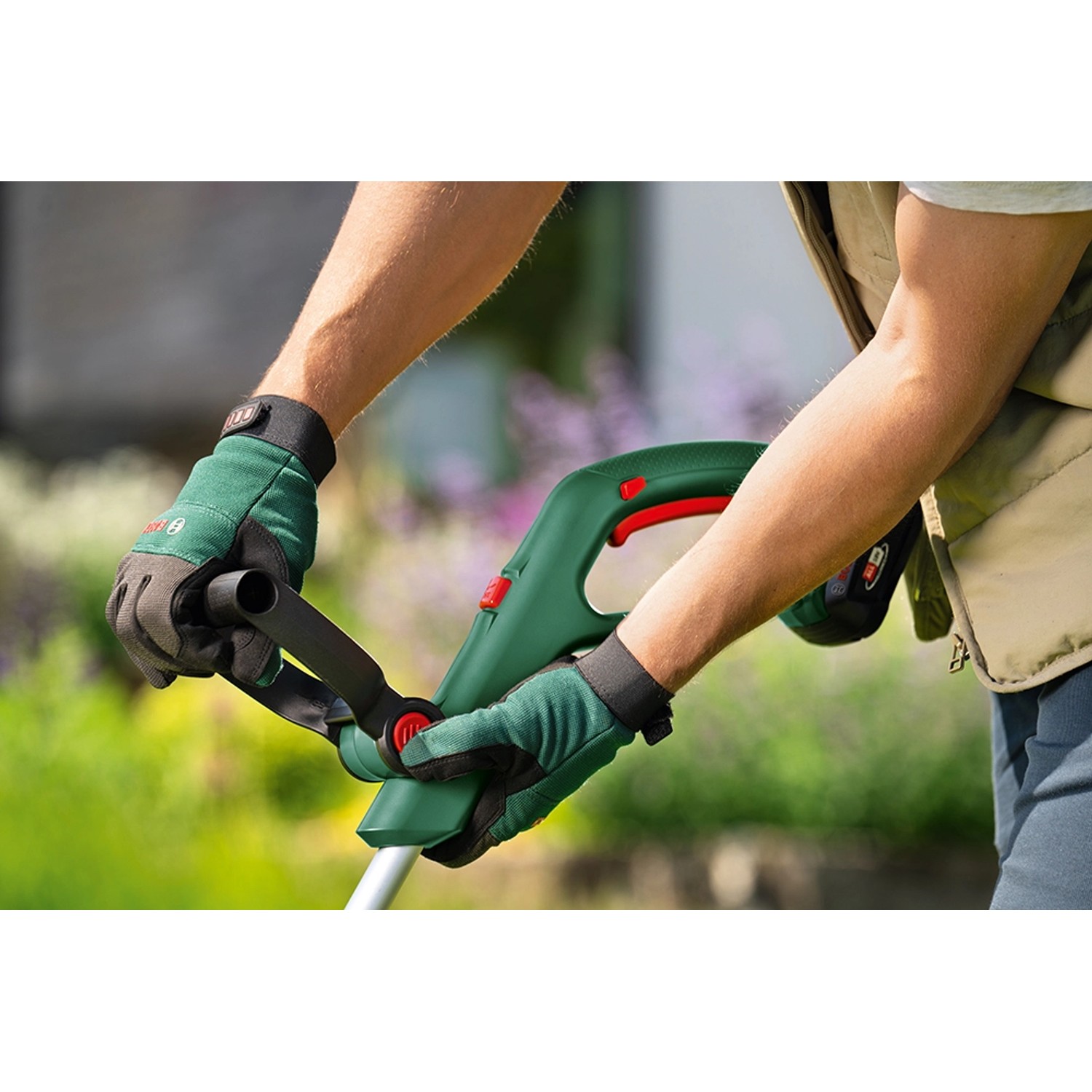 Bosch Akku-Rasentrimmer UniversalGrassCut 18V-26-500 in Benutzung, mit Akku und Ladegerät.