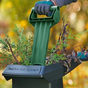 Bosch AXT 25 TC Gartenhäcksler mit Einfülltrichter und Bedienung beim Häckseln von Gartenabfällen.