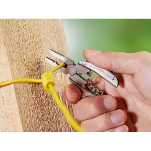 Hand nutzt LUX Multitool-Zange mit Schlüsselanhänger zum Schneiden eines gelben Kabels.
